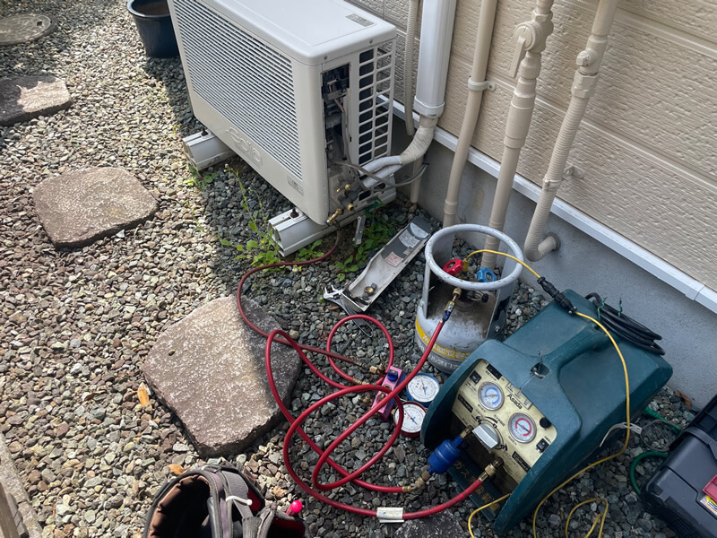 回収機を使ってフロン類をボンベに回収します